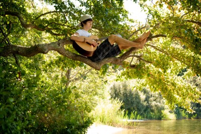 boy playing guitar in tree