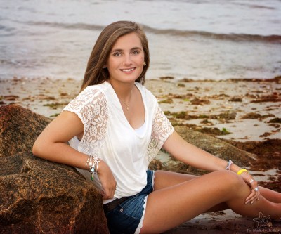High School senior girl sitting on beach