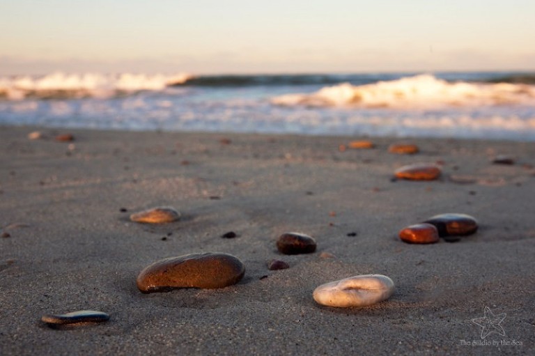 rocks on sand with ocean