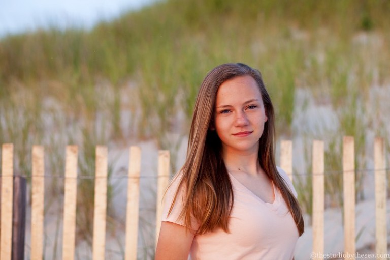 teenager by beach fence