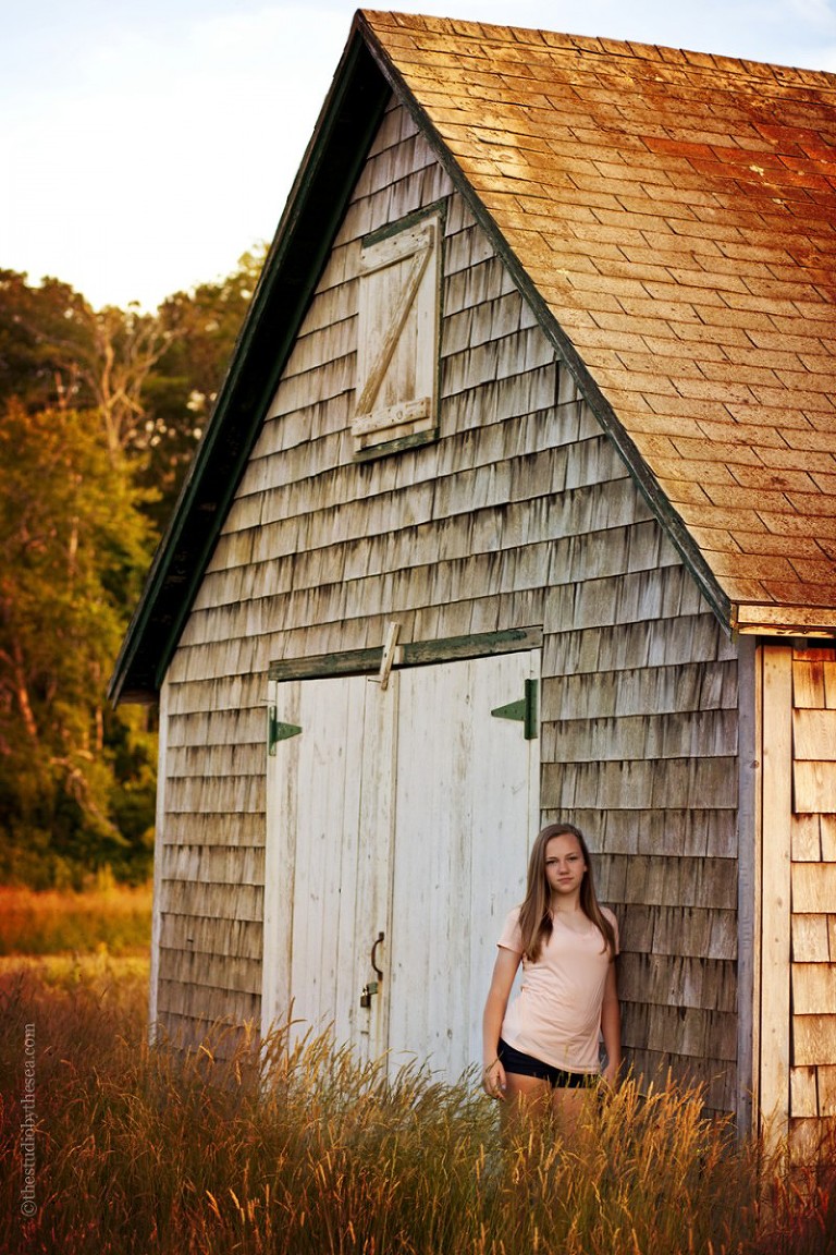 girl in field by barn
