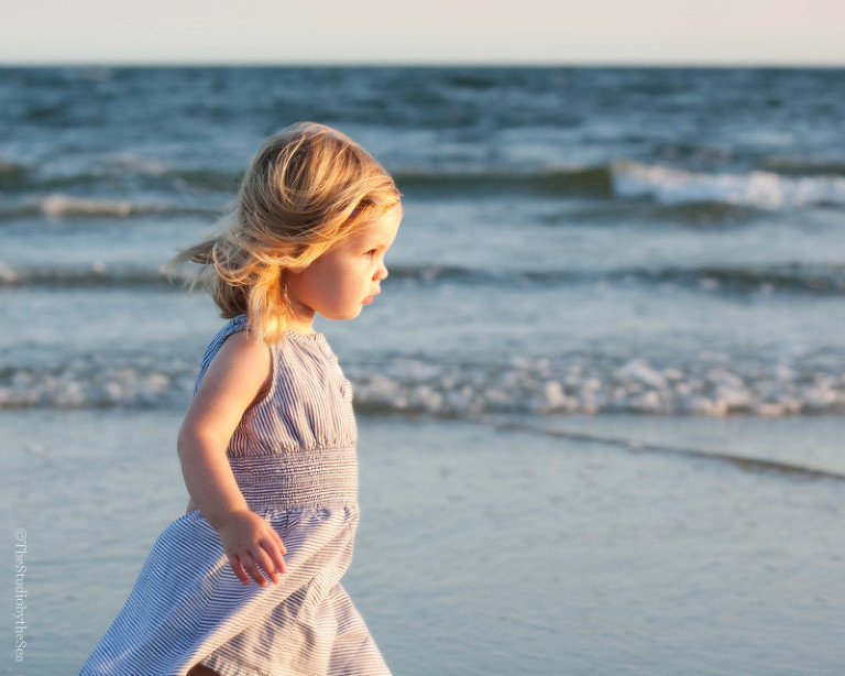 little girl walking along the edge of the shore