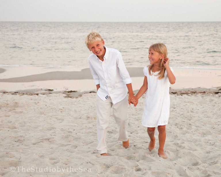 two kids laughing walking on the beach