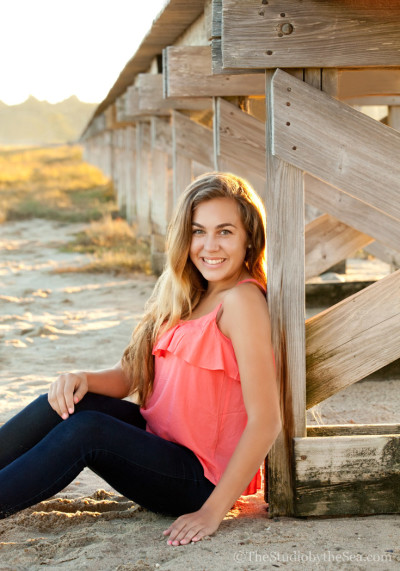 teen sitting under boardwalk