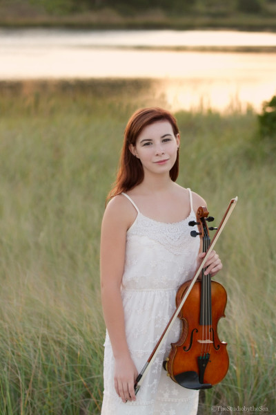 Lovely senior girl in marsh with violin