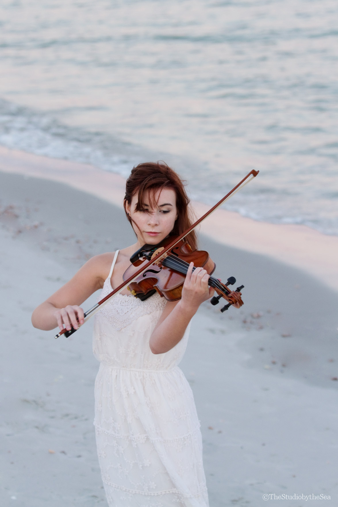 Senior girl playing violin by the sea