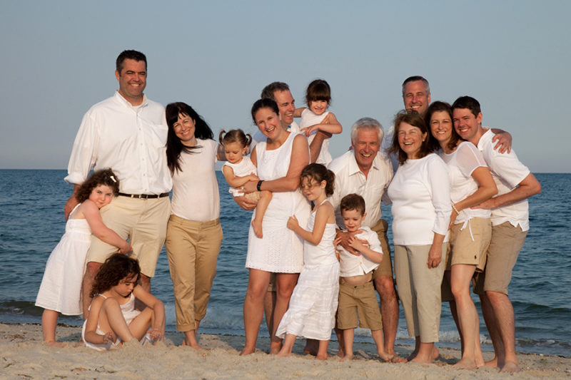 large family group in front of ocean laughing