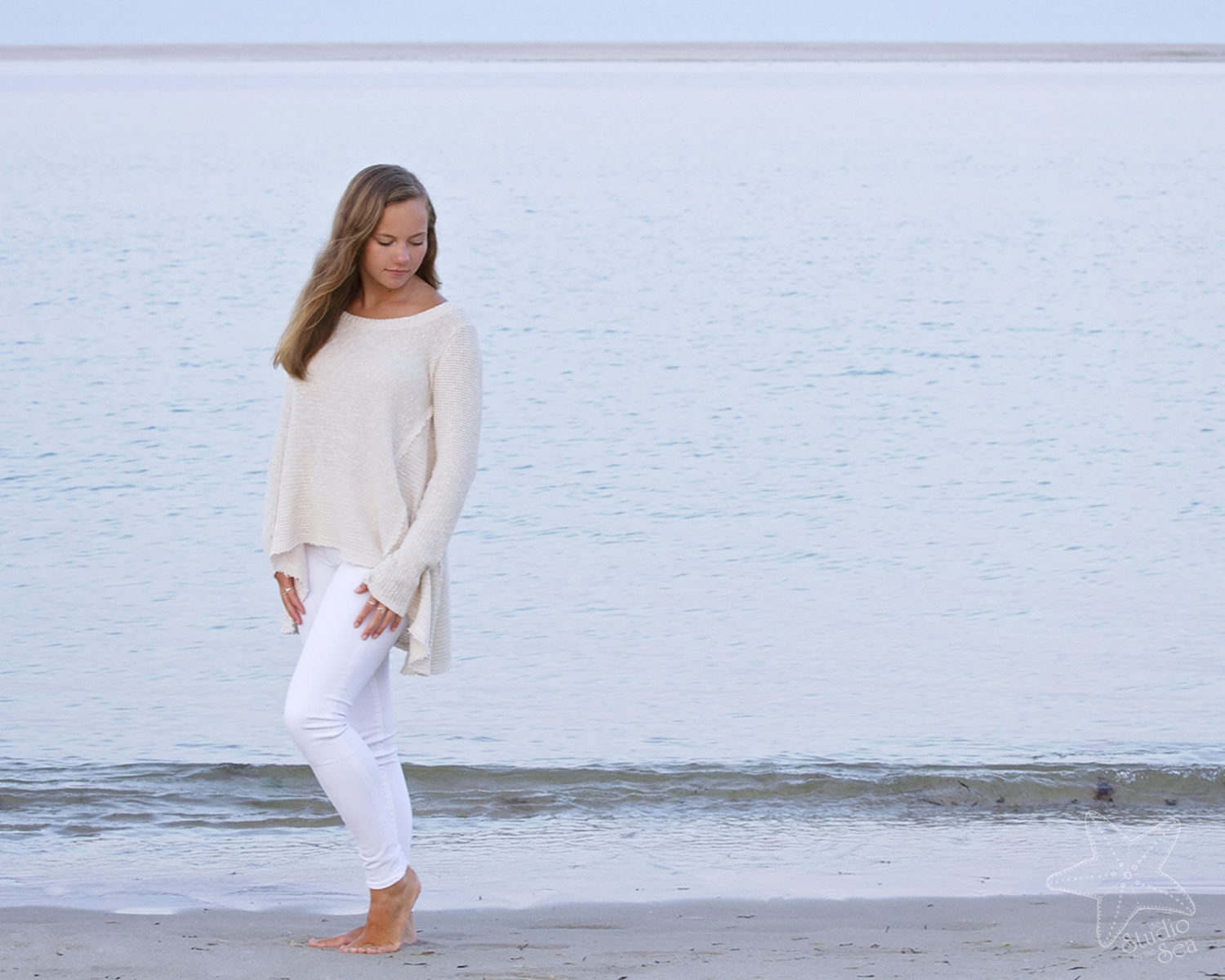 senior girl in front of ocean looking down