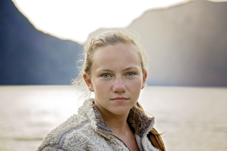 close up of girls face in front of fjords