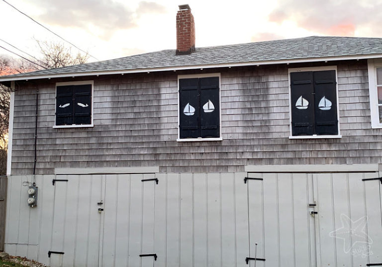 House with closed shutters, the backs of shutters have sailboats and whales stencilled on them